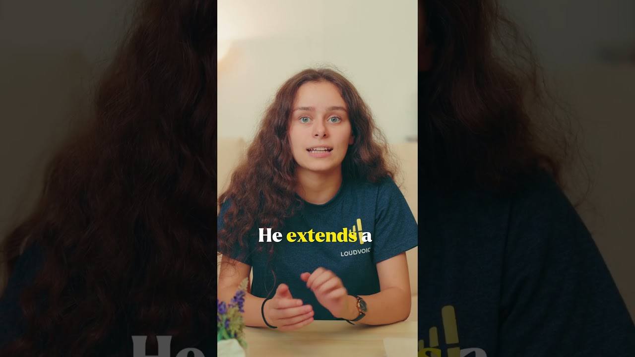 Thumbnail for the Short &ldquo;Written in the Book of Life&rdquo; — a young woman with long curly hair in a LoudVoice t-shirt, speaking to camera at a table