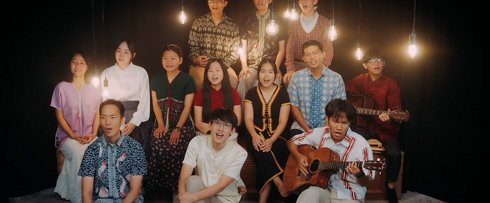 The LoudVoice ensemble singing together with guitars under hanging lights