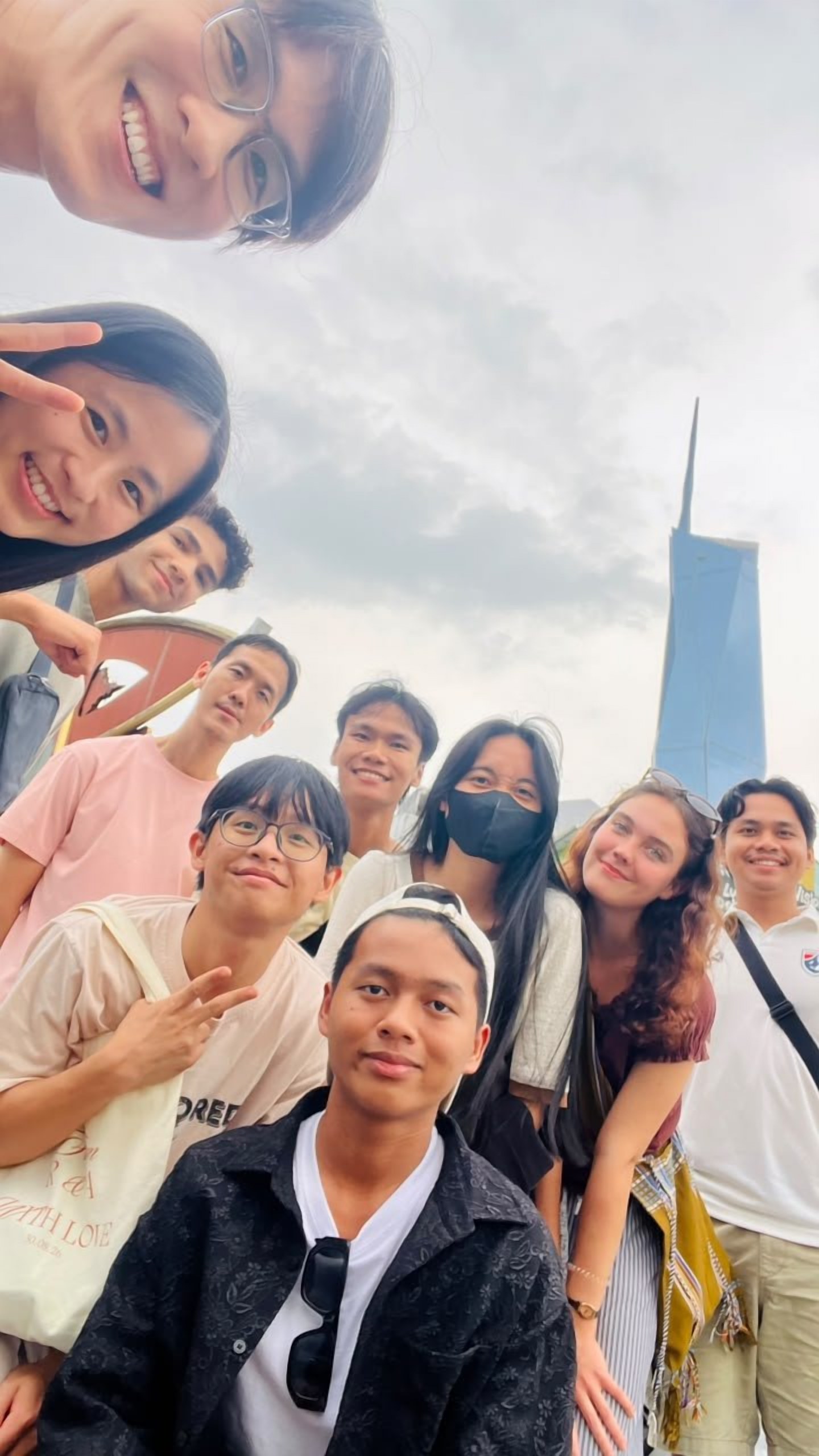 Volunteers posing in Kuala Lumpur with the Merdeka 118 tower behind them