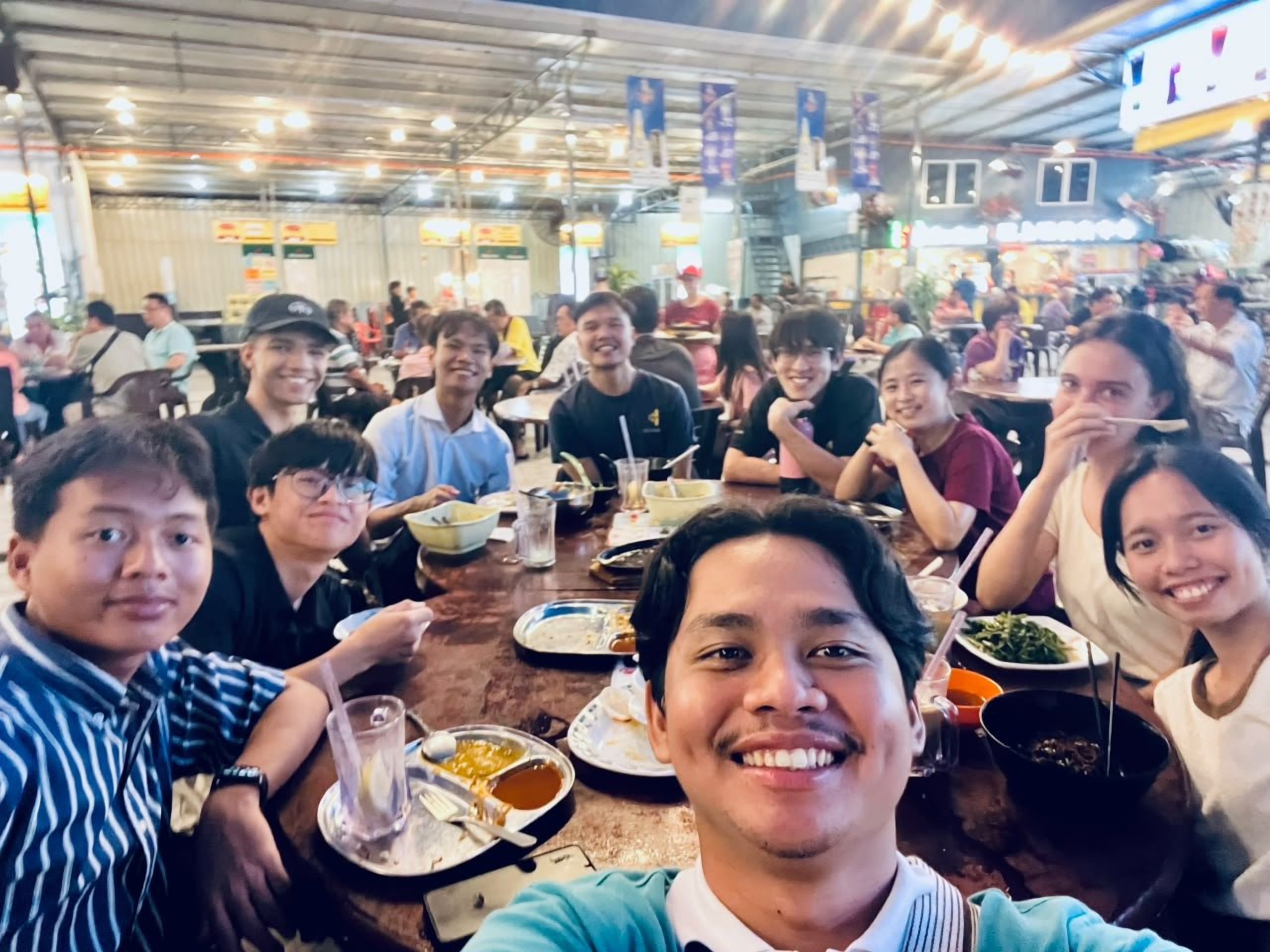 Volunteers sharing a meal together at a food court