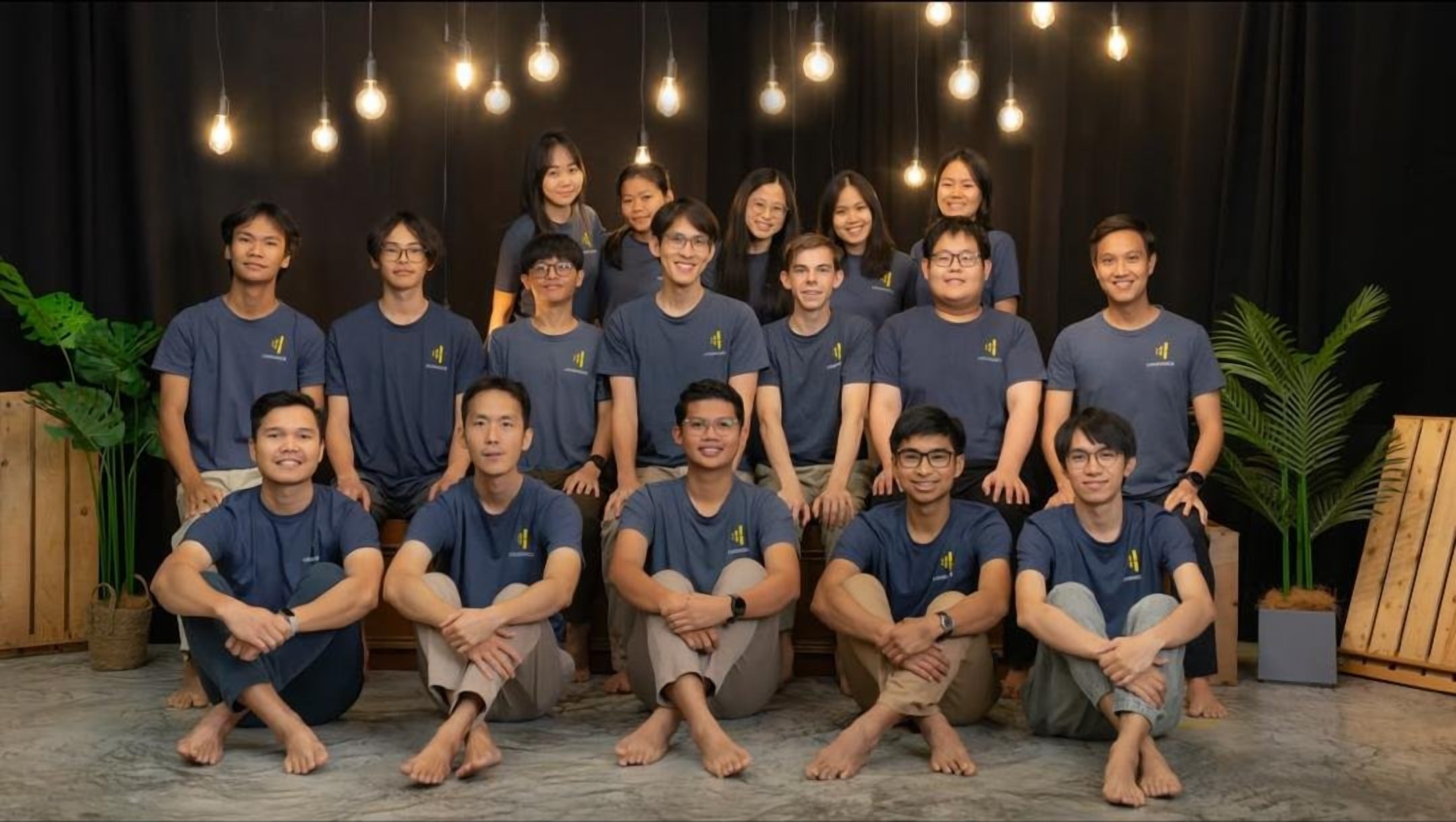 Volunteers and team in navy LoudVoice shirts under hanging bulbs in the studio